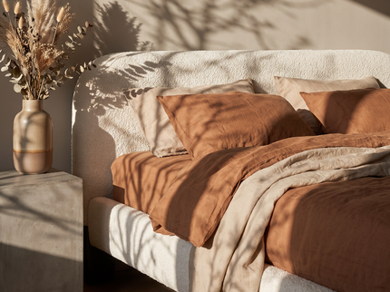Boxspring Suki Japandi opgemaakt met terracotta gestreept beddengoed