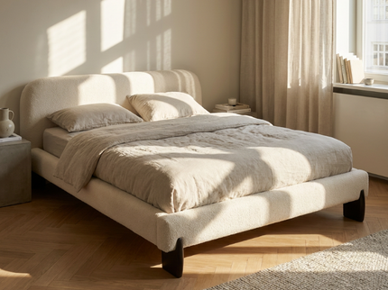 Boxspring Suki Japandi in beige bouclé stof in een lichte slaapkamer met houten vloer