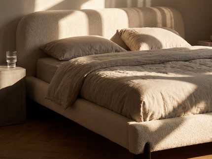 Zijaanzicht van het ronde hoofdbord van boxspring Suki Japandi met houten poten