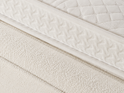 Detailfoto van de matrasstof en afwerking van de Salerno Off White boxspring